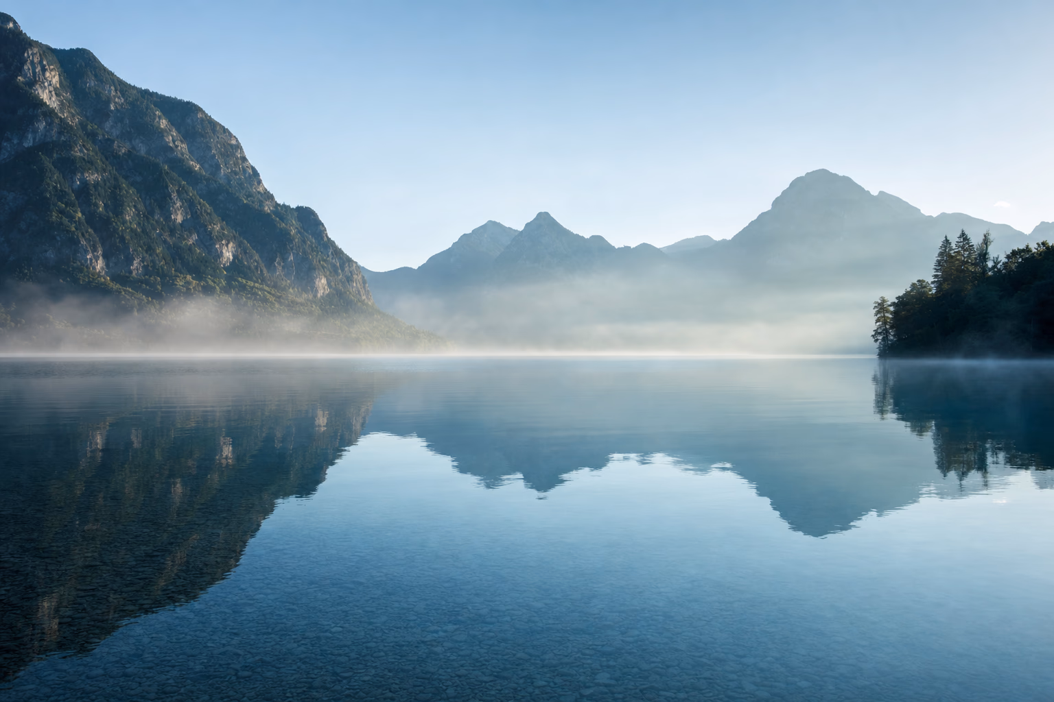 Nebliger Alpensee im Salzkammergut im Morgenlicht
