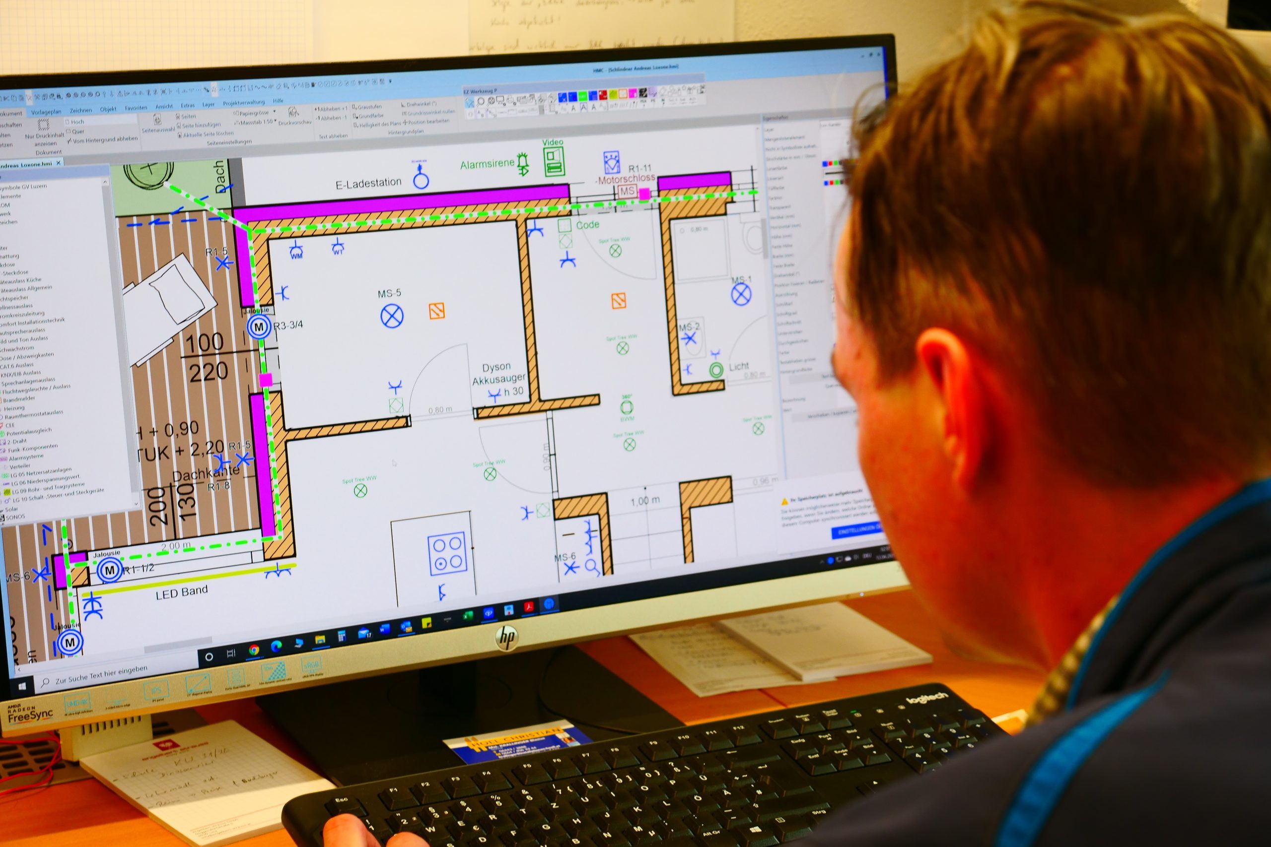 Blick über die Schulter auf einen Bildschirm mit Loxone-Elektroplan während der Projektplanung bei SES.