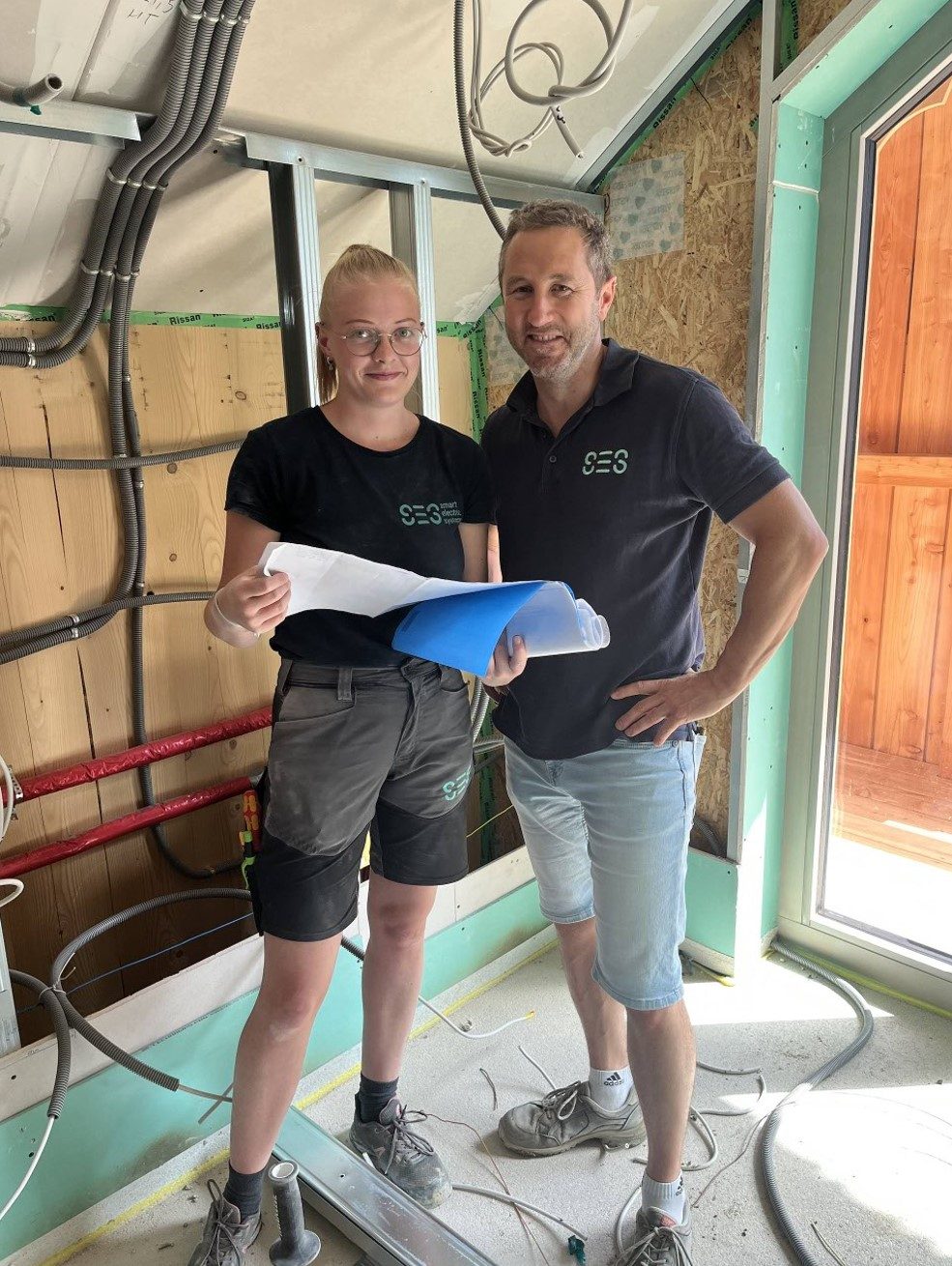 SES-Team bespricht mit Bauplänen die Rohinstallation direkt auf der Baustelle.